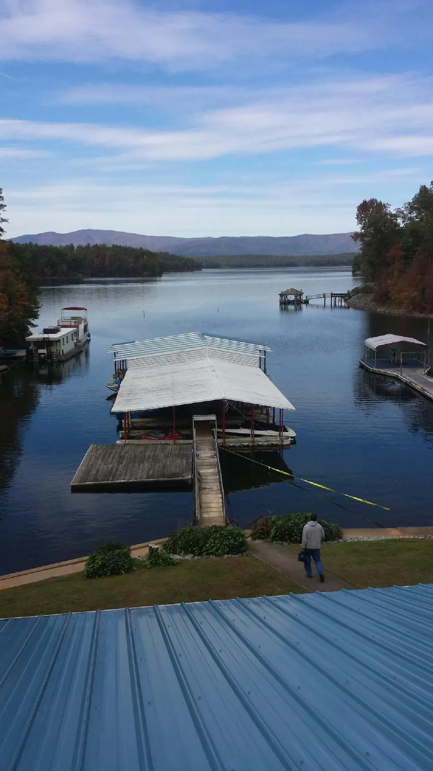 View across a lake from a newly installed blue metal roof in Mantua